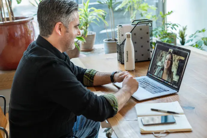 man in black sweater using macbook pro